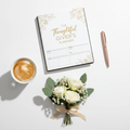 Flat-lay of a printed gifting planner on a desk with pen, coffee, and flowers