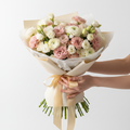 Lavish luxury bouquet of lisianthus and ranunculus in elegant wrapping