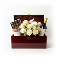 Opulent gift hamper with flowers, chocolates, candle, and wine in a keepsake box