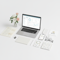 Flat-lay of business documents, laptop dashboard, and floral branding samples on a modern desk