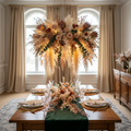 Suspended dried-flower chandelier installation over a dining table in an elegant room